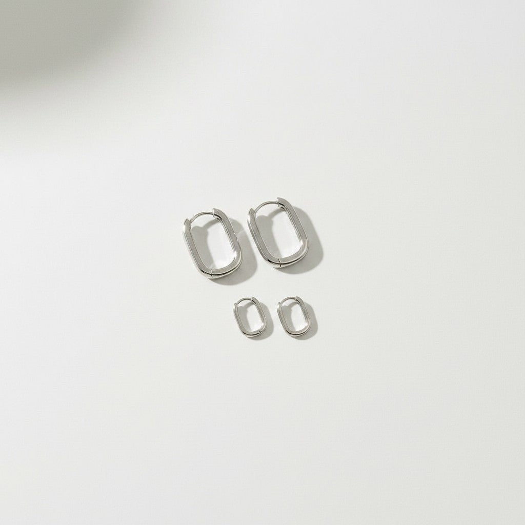 HOUSE OF EVEN Orbit Huggie Earring Set in polished silver stainless steel with two pairs of sculptural oval hoops.