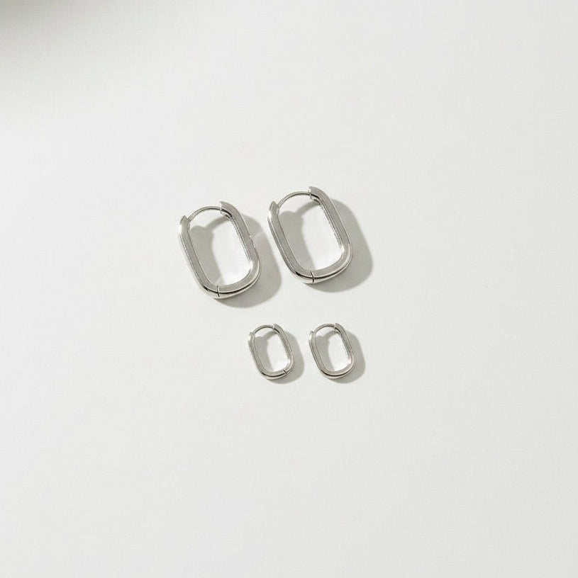 HOUSE OF EVEN Orbit Huggie Earring Set in polished silver stainless steel with two pairs of sculptural oval hoops.