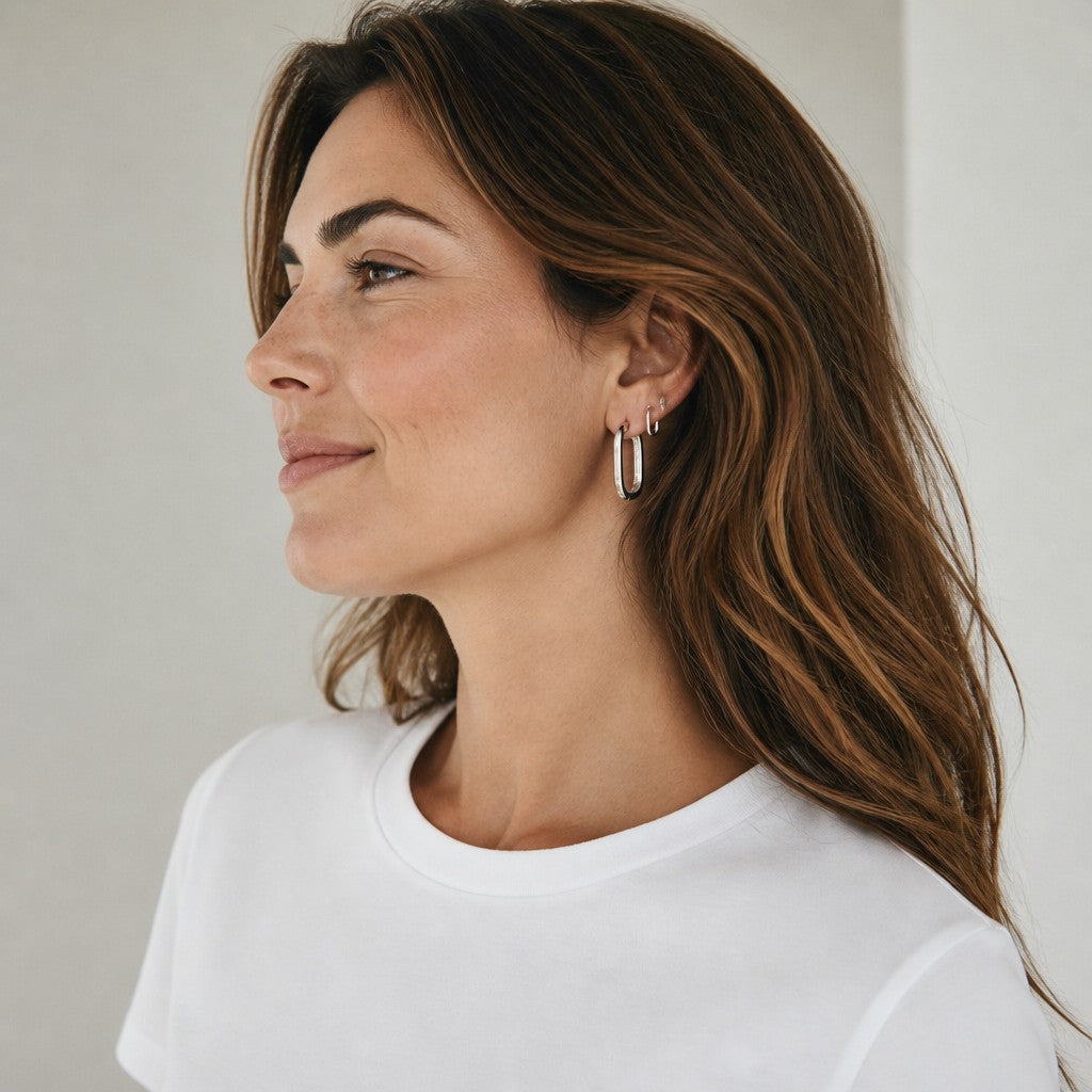 HOUSE OF EVEN Orbit Huggie Earring Set featuring two sculptural silver stainless steel hoops worn stacked on a model